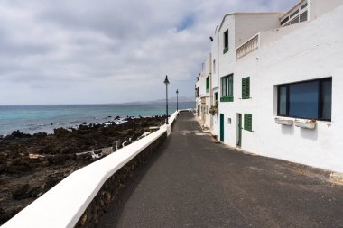 Lanzarote, İspanya - 7 Ağustos 2018: Lanzarote adasındaki küçük Punta Mujeres kasabası bulutlu bir günde doğal yüzme havuzlarıyla ünlüdür.