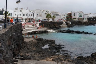 Lanzarote, İspanya - 7 Ağustos 2018: Lanzarote adasındaki küçük Punta Mujeres kasabası bulutlu bir günde doğal yüzme havuzlarıyla ünlüdür.
