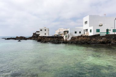 Lanzarote, İspanya - 7 Ağustos 2018: Lanzarote adasındaki küçük Punta Mujeres kasabası bulutlu bir günde doğal yüzme havuzlarıyla ünlüdür.