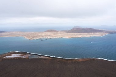 Bulutlu bir günde Mirador del Rio 'dan Lanzarote' deki Graciosa adasının fantastik manzarası