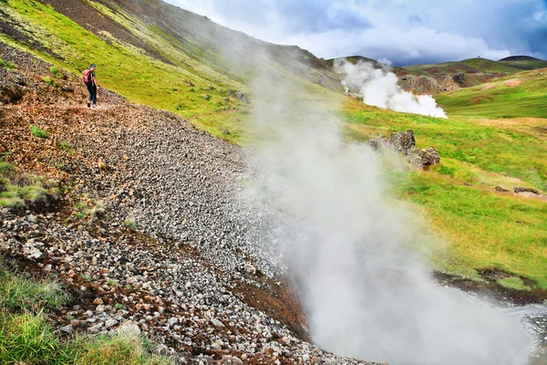 Senderismo femenino en sendero en un hermoso paisaje geotermal a lo largo de géiseres en Hveravellir, Islandia —  Fotos de Stock