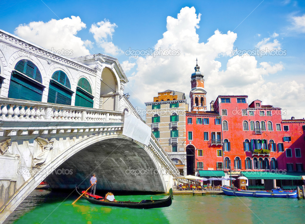 Famous Ponte di Rialto with traditional Gondola under the bridge in Venice, Italy