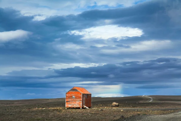 Paysage aride avec ancien abri de tempête de neige rouge sur la route des hautes terres de Kjolur, Islande — Photo