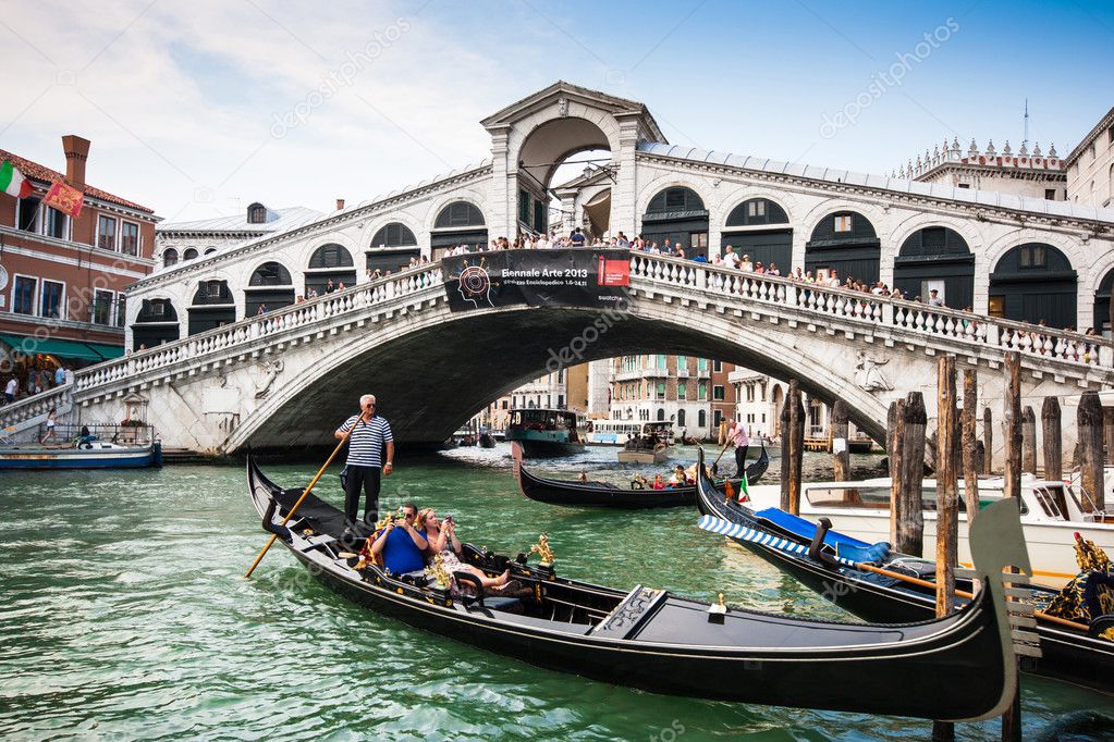 VENICE - JULY 11: Traditional gondolas and boats on Canal Grande at famous Rialto bridge on July 11, 2013 in Venice, Italy. The high traffic volume on Canal Grande is one of the city's major concerns.