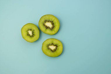 Mavi arka planda taze kivi yarıları. Olgun sulu kivi.. 