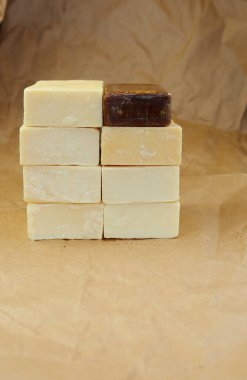 Light and dark bar of soap on a background of crumpled paper. The bars of soap were placed on top of each other. 