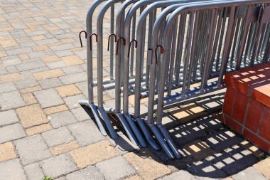 Sokakta taşınabilir bölgesel çit var. Yakınlarda bir sürü boyanmamış metal çit var..