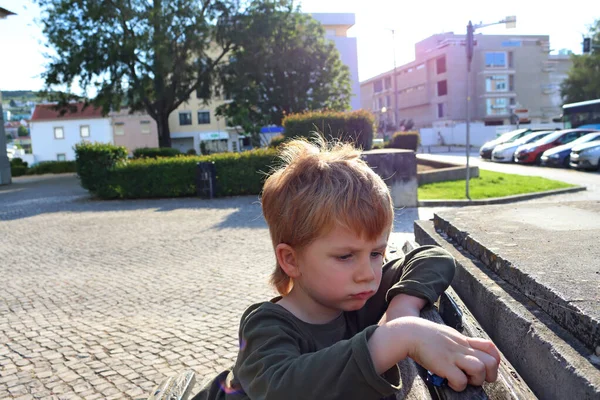 Sarışın çocuk yanaklarını şişirdi ve aşağıya baktı. Parlak güneşin arka planında beş yaşındaki bir çocuğu gücendirmiş..