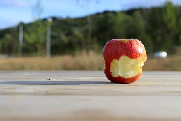 Une Pomme Rouge Mordue Sur Fond Vert Flou — Photo