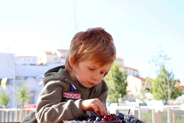 Een Blonde Jongen Laat Zijn Ogen Zakken Plukt Fruit Van — Stockfoto