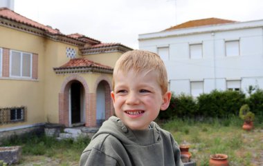 Sarışın çocuk gözlerini kıstı ve dişlerini gösterdi. Beş yaşındaki çocuk yüzünü buruşturdu..