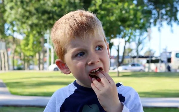 금발의 소년은 벌리고 넣는다 살짜리 아이가 정크푸드를 탐욕스럽게 먹습니다 — 스톡 사진