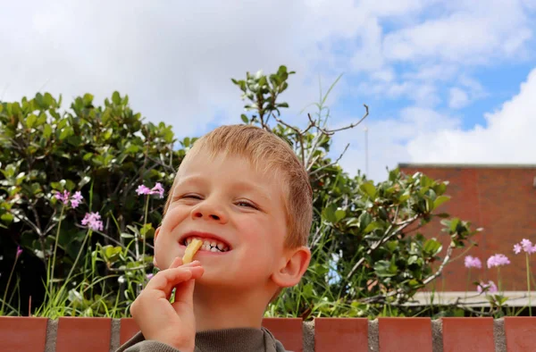 Blonde Jongen Leunt Zijn Hoofd Achterover Bijt Patat Speelse Vijfjarige — Stockfoto