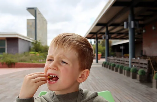Blondyn Zmarszczył Brwi Zjadł Frytki Poważny Pięciolatek Lunch Ulicznej Kawiarni — Zdjęcie stockowe