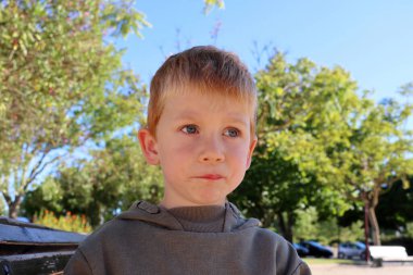 Sarışın çocuk alt dudağını ısırdı ve dikkatlice uzaklığa baktı. Gergin beş yaşında bir çocuk..