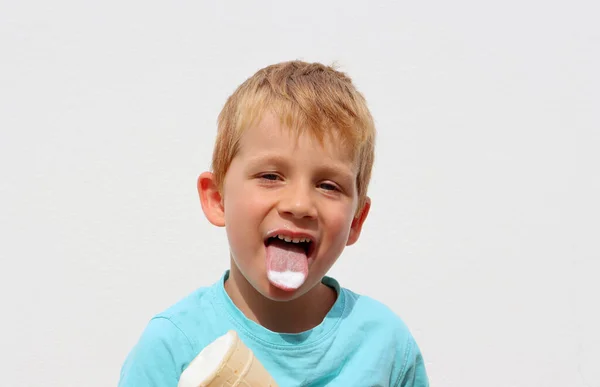 금발의 소년은 아이스크림을 보여준다 배경에 대항하는 — 스톡 사진