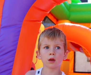 Şaşırmış gözleri ve aralık ağızlı sarışın bir çocuk. Afallamış beş yaşında bir çocuk.. 