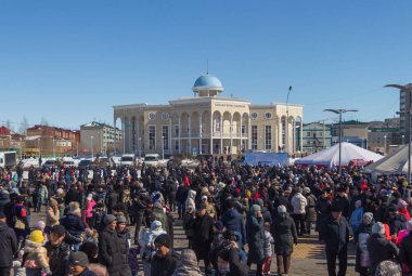 Uralsk, Kazakistan, 22.03.2022 - Kazakistan 'da bahar tatili, festivalde bir grup insan, arka planda Kazakistan Halk Meclisi Dostluk Evi