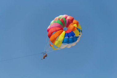 Türkiye, 30.08.2021: Türkiye 'de Parasailing. Deniz üstünde paraşüt. Olağanüstü eğlence, paraşütle atlayan turistler bottan halata tırmanıyor.