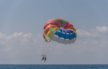 Türkiye, 30.08.2021: Türkiye 'de Parasailing. Deniz üstünde paraşüt. Olağanüstü eğlence, paraşütle atlayan turistler bottan halata tırmanıyor.