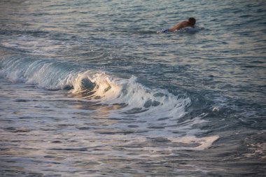 Türkiye, 2.09.2021: Deniz dalgası. Yalnız bir adam denizde yüzer. Yalnız seyahat etmek. İnsan ve deniz.