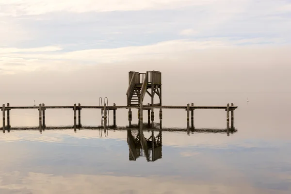 Muelle de madera con orilla durante la temporada de invierno —  Fotos de Stock