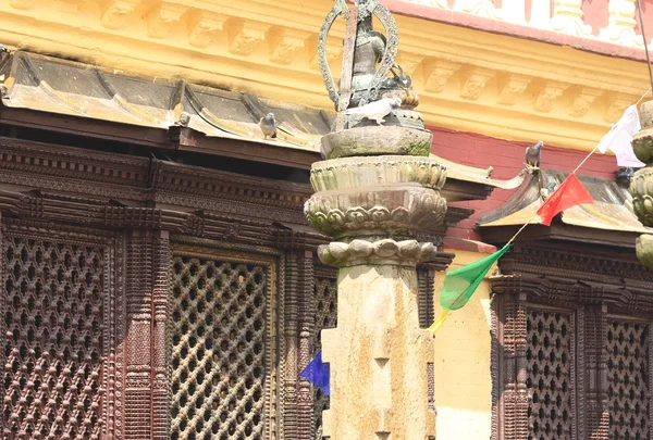 Buildings, columns, Buddha statue, prayer flags, around Swayambhunath Stupa. — Stock Photo, Image