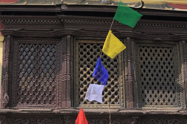 Буддийские молитвенные флаги перед деревянным окном . — стоковое фото