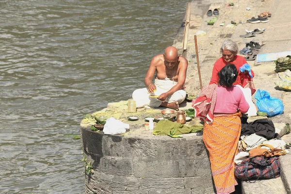 Bhatta priest-two faithful women. Pashupatinath temple-Bagmati river-Deopatan-Kathmandu-Nepal. 0288 — Stock Photo, Image