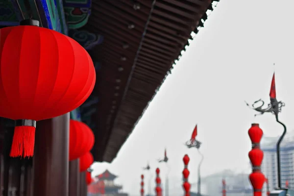 Chinese red lanterns on a sentry building-set of palace lanterns and red pennants hanging from a wrought iron flagpole-walkway atop the City Wall in the Yongning-South Gate area. Xi\'an-Shaanxi-China.