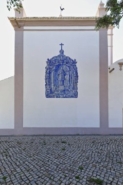 Azulejo-tile image of Sao Lourenco-Saint Lawrence placed in 1730 on the east-rear facade of the Igreja Matriz-Main Church erected in his devotion. Almancil parish-Loule municipality-Algarve-Portugal.