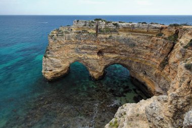 Praia da Marinha Sahili 'nin batı ucundaki Praia da Mesquita Katedrali' nin yanındaki M Rock veya Katedrali Yedi Asılı Vadi 'den E.to W.s. Lagoa-Algarve-Portekiz.