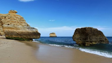 Praia da Marinha Sahili 'nin batı yakasında, jeolojik Lagos-Portimao oluşumunun yamaçlarındaki deniz erozyonunun oyduğu izole edilmiş deniz yığınları ve kayalar. Lagoa-Alagarve-Portekiz.