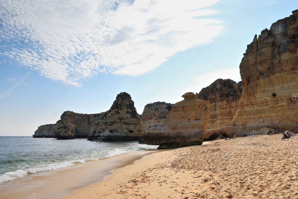 Isolated free-standing sea stacks and islets at the west end of Praia da Marinha Beach carved by marine erosion at the cliff foot of the geological Lagos-Portimao Formation. Lagoa-Alagarve-Portugal.