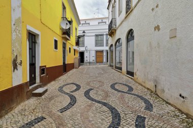 Cobblestone, şehrin tarihi merkezinde bulunan Rua da Estrema Caddesi 'ni, birbirine dolanmış çizgiler desenli sarı-kahverengi ve beyaz renklerle kaplamıştı. Lagos-Algarve-Portekiz.