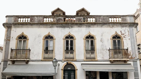 Wybielona Fasada Starego Dwupiętrowego Neoklasycystycznego Domu Rozdrobnioną Farbą Ostrymi Łukami — Zdjęcie stockowe