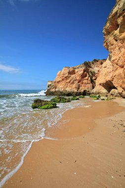 Praia da Prainha Sahili 'nin orta kesimindeki deniz yığınları ve uçurumların dibinde deniz dalgaları tarafından oyulmuş doğal mağaralar ve delikler. Alvor Portimao-Algarve-Portekiz.