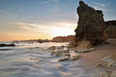 Praia do Amado Sahili üzerinde gün batımını gösteren uzun bir sergi doğudan batıya, alacakaranlık manzaralı Ponta de Joao d 'Arens' e çekildi. Portimao-Algarve-Portekiz.