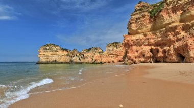 Praia da Prainha Sahili 'nin en batısındaki deniz yığınları ve uçurum ayağına oyulmuş rüzgar mağaraları tarafından oyulmuş doğal delik. Alvor Portimao-Algarve-Portekiz.
