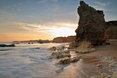 Praia do Amado Sahili üzerinde gün batımını gösteren uzun bir sergi doğudan batıya, alacakaranlık manzaralı Ponta de Joao d 'Arens' e çekildi. Portimao-Algarve-Portekiz.