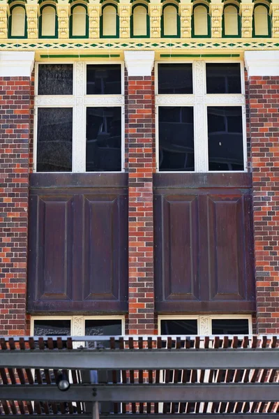 Queen Caddesi 'nde 1920' lerden kalma Art Deco tarzı miras binasının ayrıntılı pencereleri inşaat alanındaki ticari bir alışveriş merkezinin yıkımından korunmuş. Brisbane-Queensland-Avustralya.