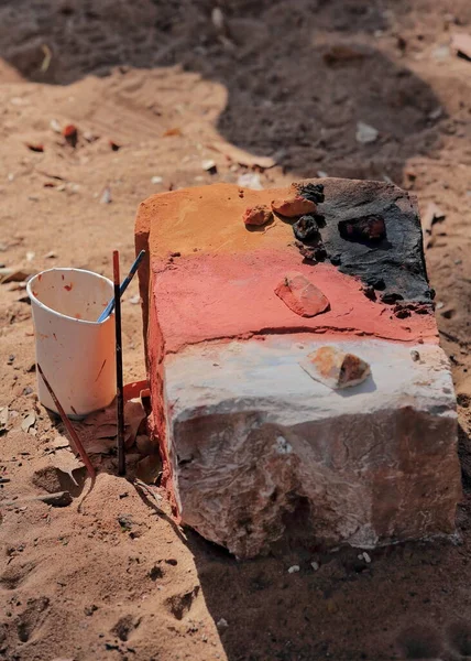 Square stone block used as a table for preparing pigments to be used in australian aboriginal painting: ochre rock powder for orange-red colors, charcoal for black, clay for white. Darwin-NT-Australia