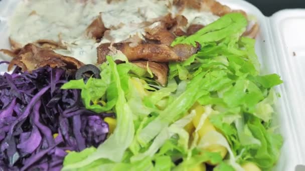 Kebab, gyros, shawarma en una tabla, envuelto en un paquete desechable. Rota en un plato. Movimiento cíclico — Vídeo de stock