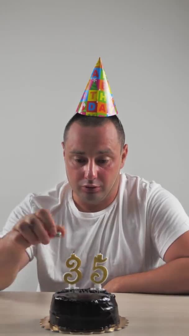 Святкування дня народження наодинці. день народження хлопчик запалює свічки на торт протягом 35 років і співає. вертикальне відео — стокове відео