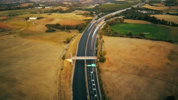 Nagranie z dronów powietrznych. samochody długodystansowe jadące po ruchliwej autostradzie we Włoszech. Pola uprawne i wzgórza w tle — Wideo stockowe