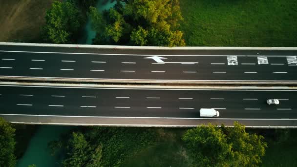 Filmato del drone aereo. Camion semirimorchi a lungo raggio Guida sull'autostrada trafficata nella Regione Rurale d'Italia. Campi agricoli e colline sullo sfondo — Video Stock