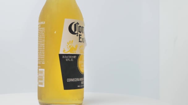 Rom Italien, 16. Juli. 2021. Eine Flasche Corona Extra Bier mit Limette auf weißem Hintergrund, das, wie der größte Teil des weltweit verkauften Bieres, von Cerveceria Modelo in Mexiko hergestellt wird. — Stockvideo