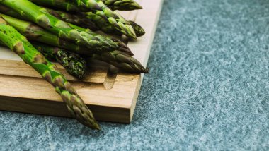 Kuşkonmaz. Gri bir arka planda taze yeşil kuşkonmaz. Üst görünümü kopyala