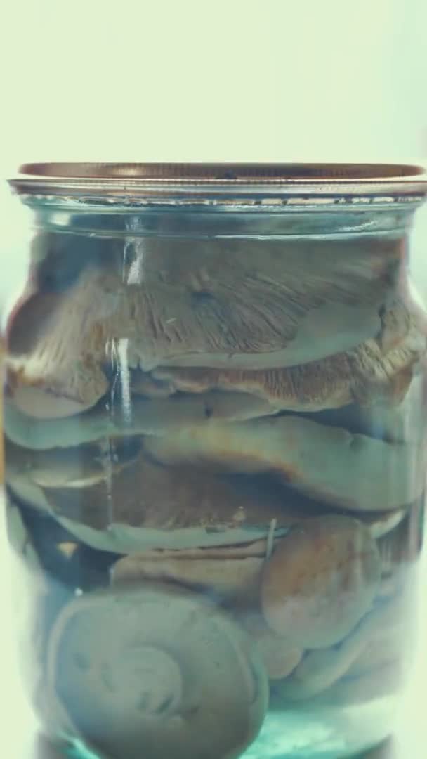 Gros plan, champignons crus marinés dans un bocal en verre, nourriture tournant sur un fond blanc. épicerie en ligne. livraison de nourriture. conserves alimentaires — Video