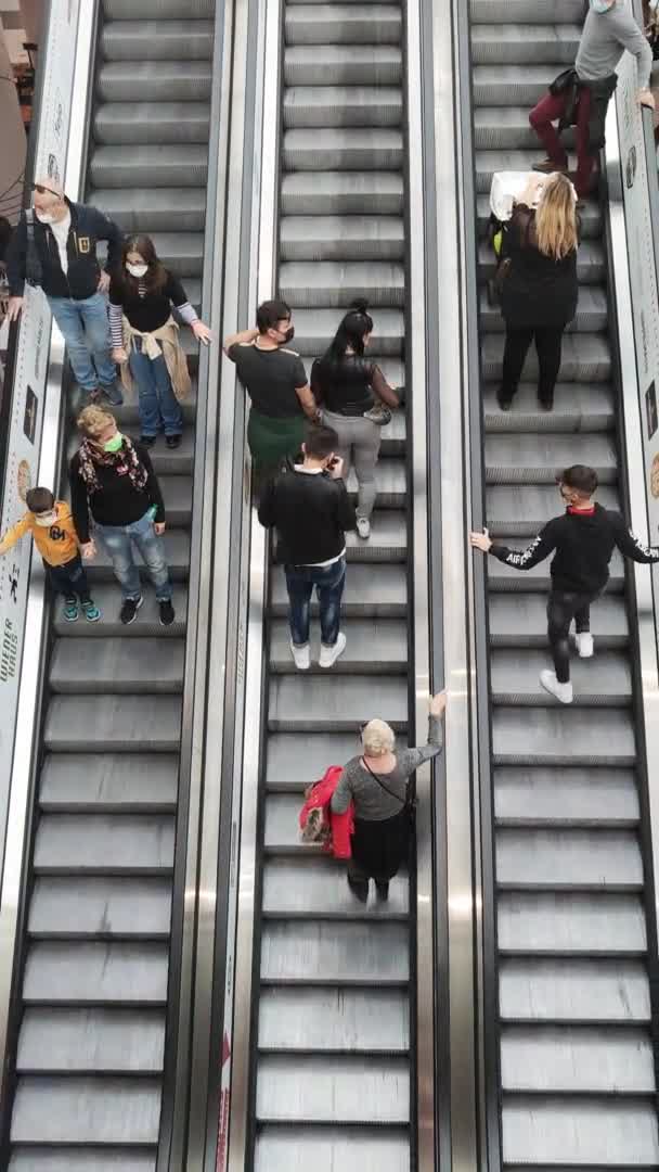Os compradores usam escada rolante no Shopping Center. vídeo vertical — Vídeo de Stock